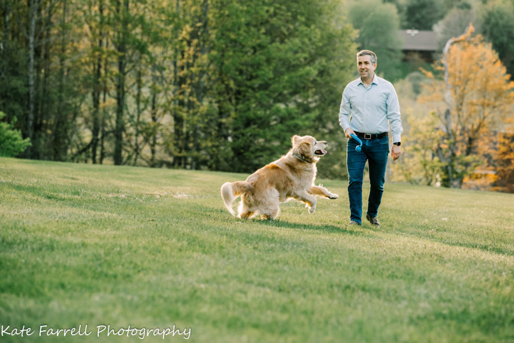 Kate Farrell's photo of a man playing with a dog. Vermont family reunion photograph