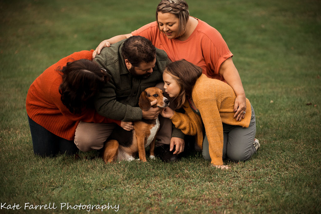 Mom, Dad, two daughters and their beagle kneeling in their yard. Fun example of a fall family photo. 