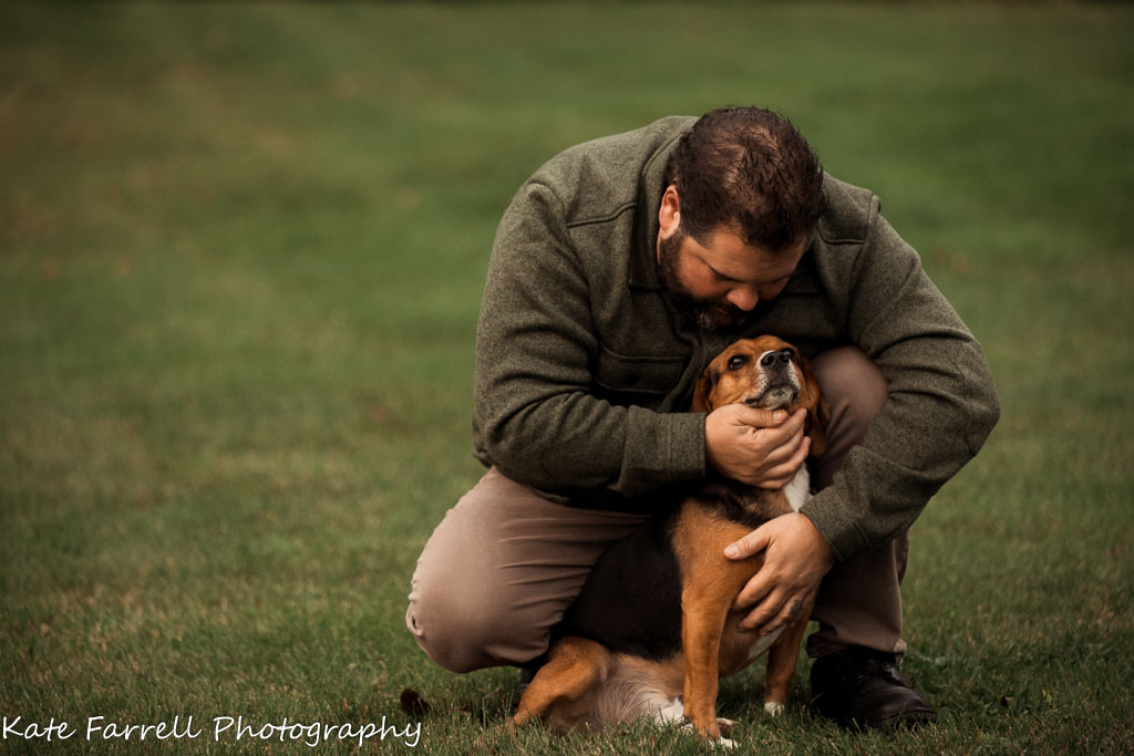 Close up of man hugging his beagle.