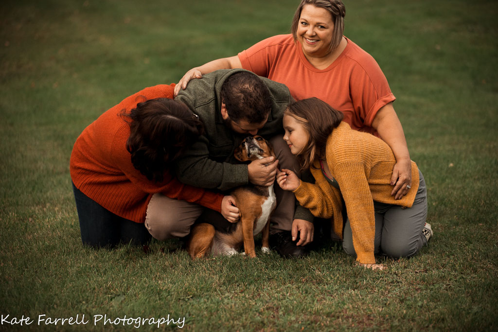 Family hug with a very happy mom, dad, two daughters and a dog. Fun picture to show a proud mother and her family. 