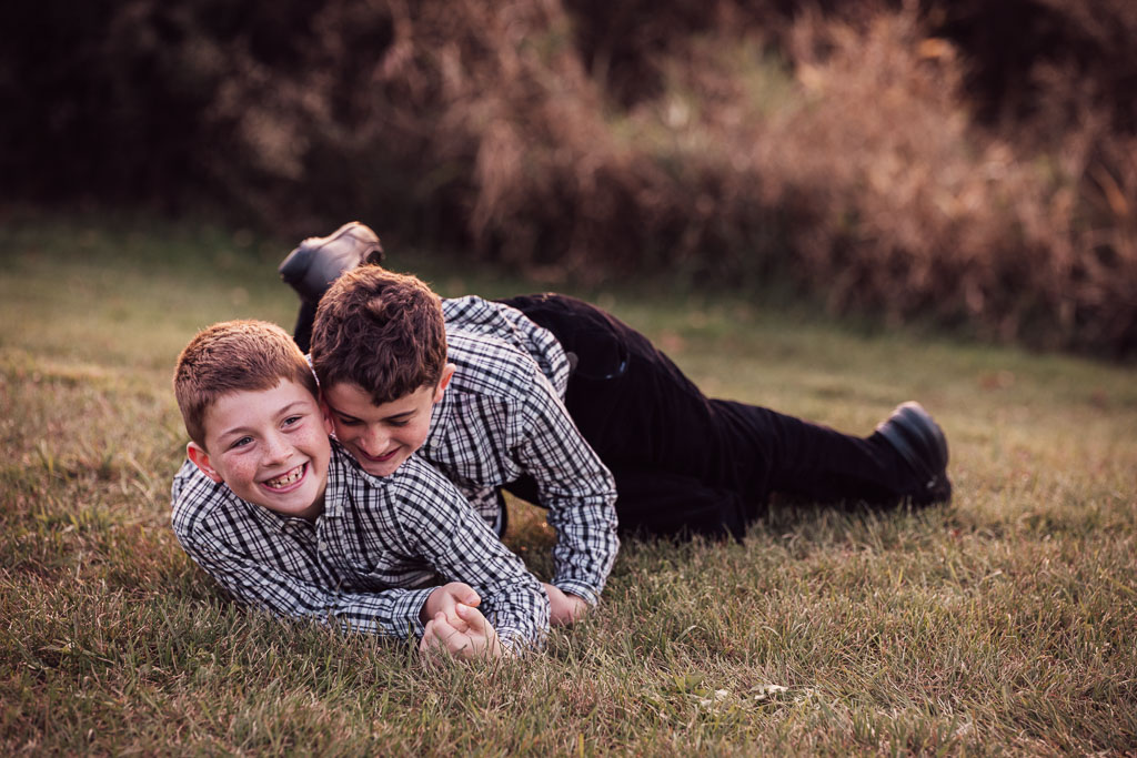 Two brothers playing on the ground.