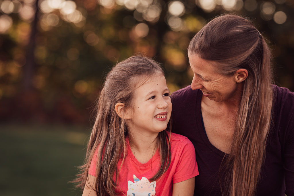 Mom looks lovingly at 6 year old daughter.