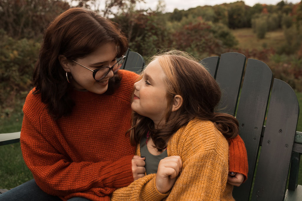 Image of two sisters hugging at one of my Vermont Family Photo Sessions