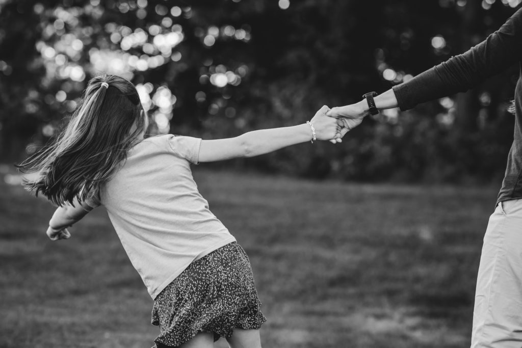 Black and white photo of a mother and 6 year old daughter playing. An example of family photography.