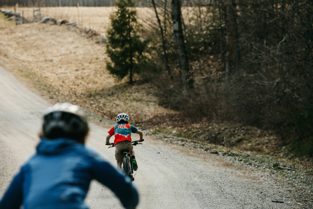 Two young boys ride bikes in the spring.