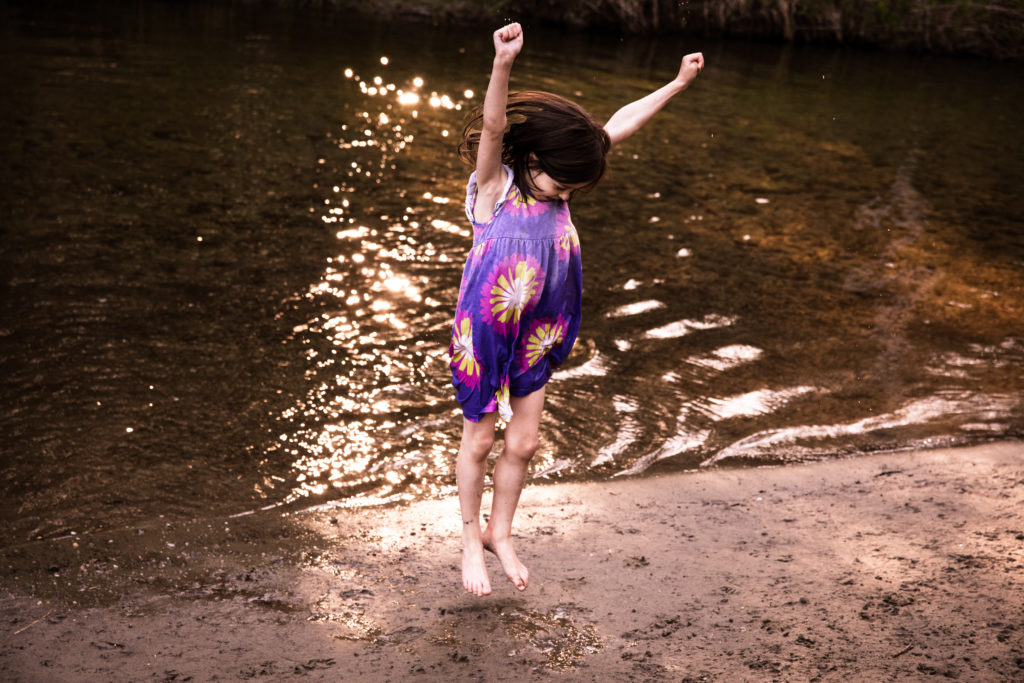 Girl celebrating near a stream. 