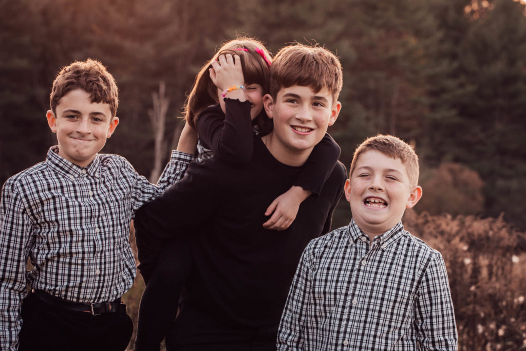 Four siblings having fun, a moment captured by a family photographer.