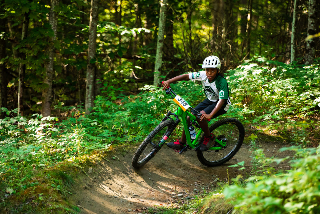 Rider in the Vermont Youth Cycling Race at Craftsbury 2022 navigating a berm.
