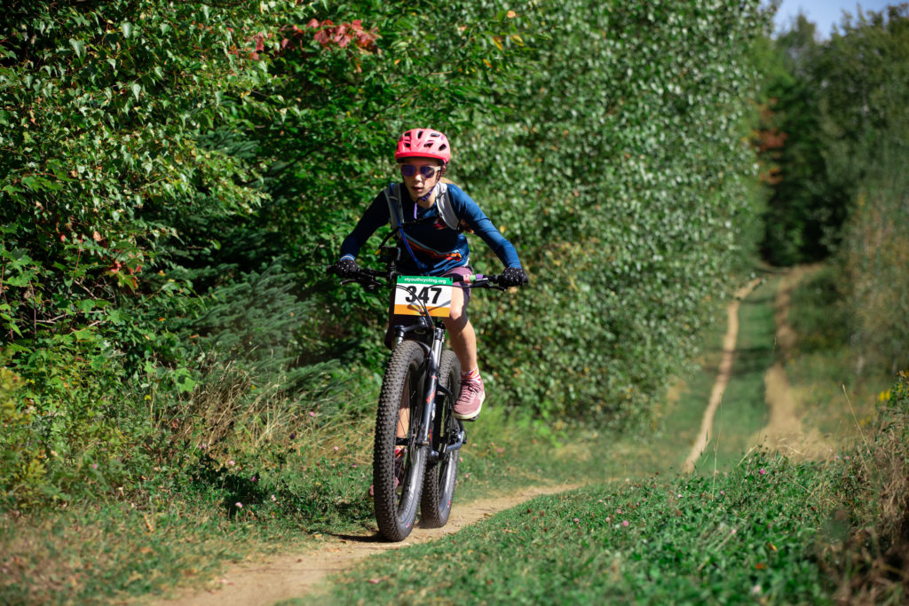  Vermont Youth Cycling Race at the Kingdom Trails. A girl in blue mountain biking.