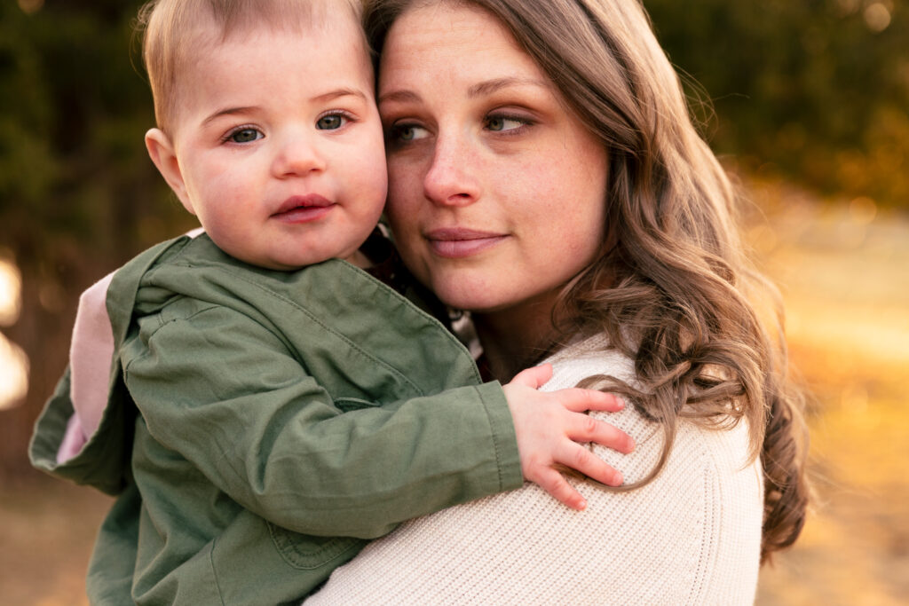 Mom gives her toddler a hug -- close up photo from an outdoor family photo session.